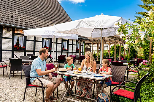Familie isst auf der Restaurantterrasse auf dem Campingplatz CAPFUN Tecklenburg in Tecklenburg-Leeden (49). Familie isst auf der Restaurantterrasse auf dem Campingplatz CAPFUN Tecklenburg in Tecklenburg-Leeden (49).